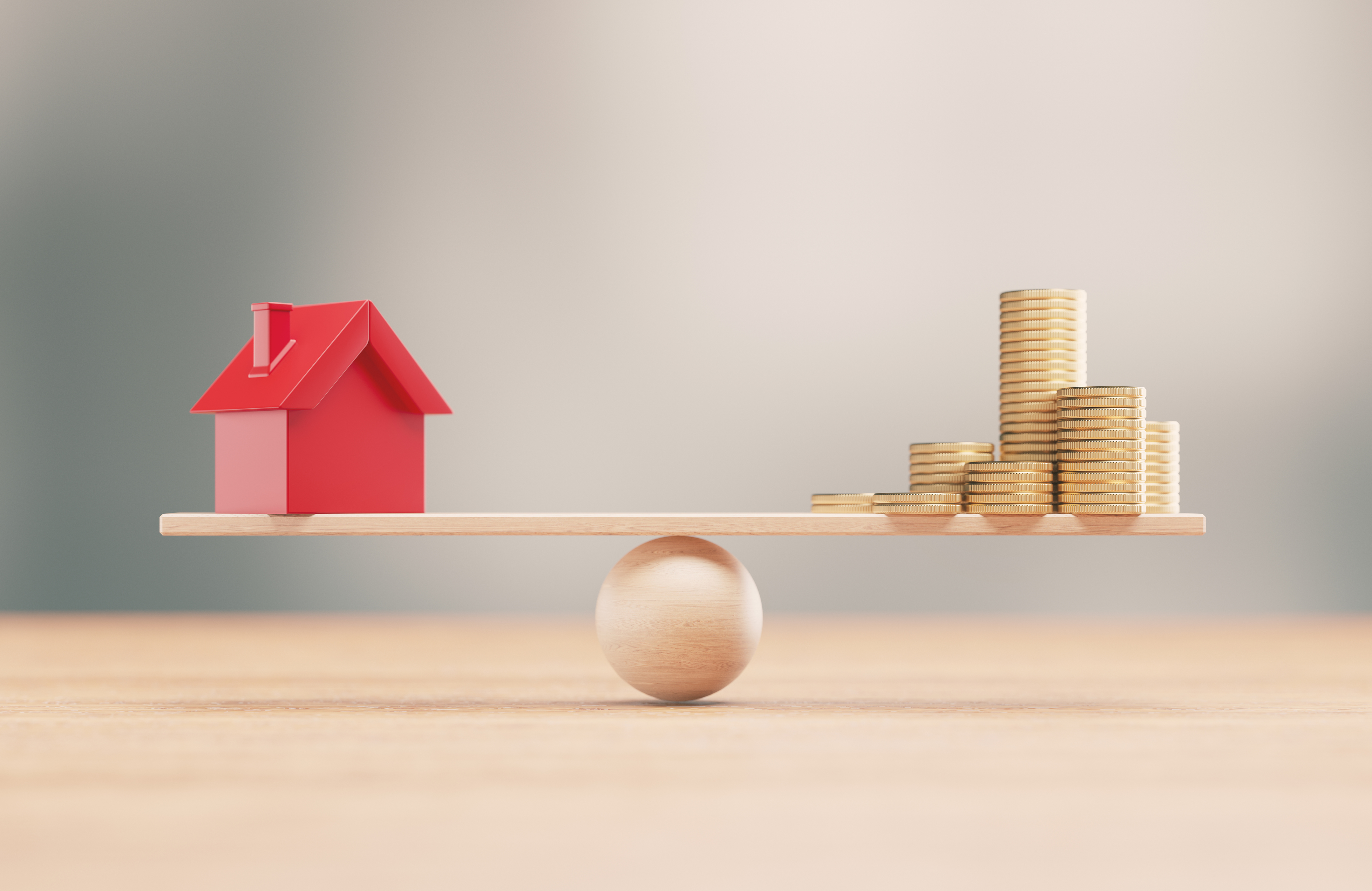 A figurine of a house and coins balancing against eachother