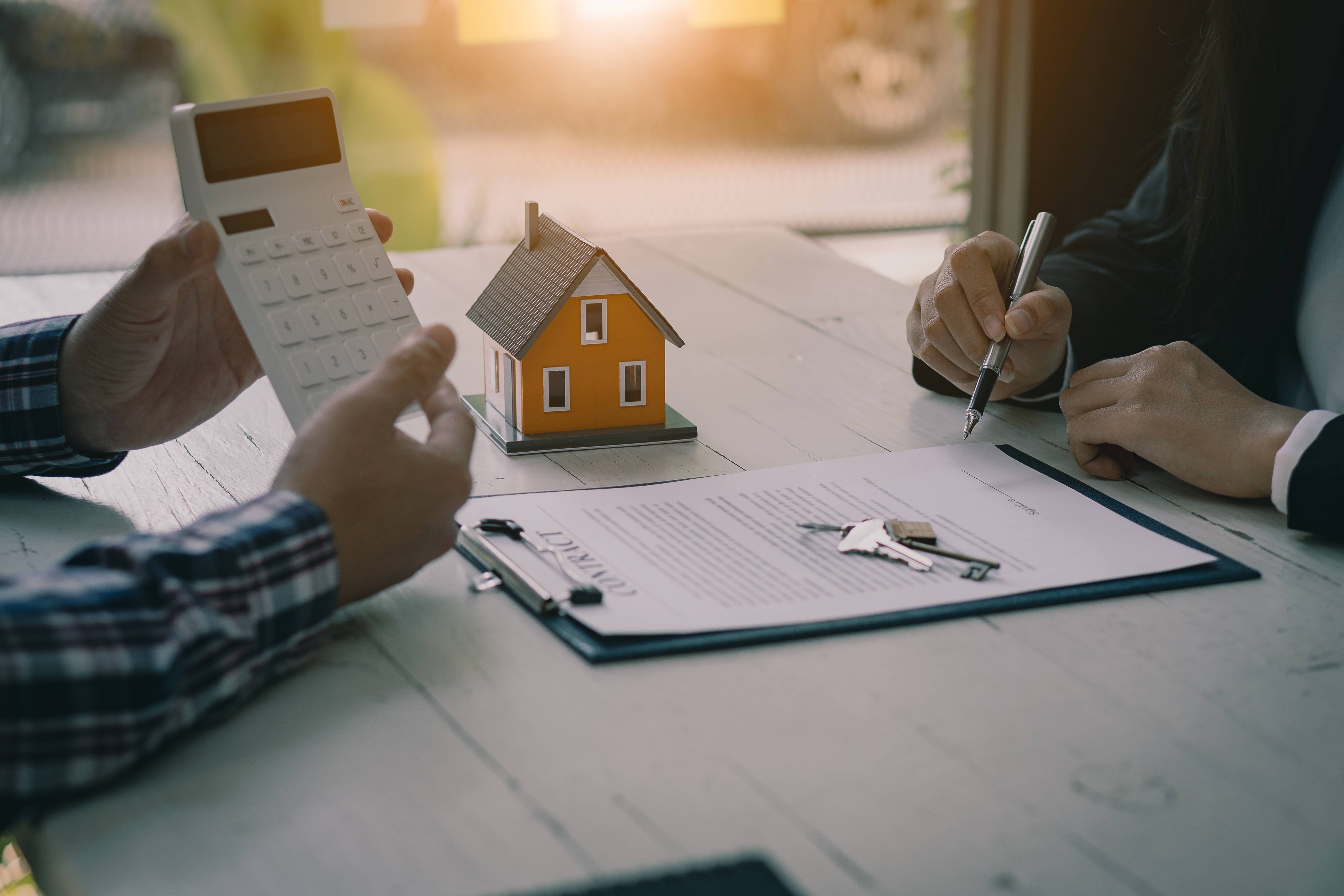 people-reviewing-documents-with-calculator-and-clipboard-on-table
