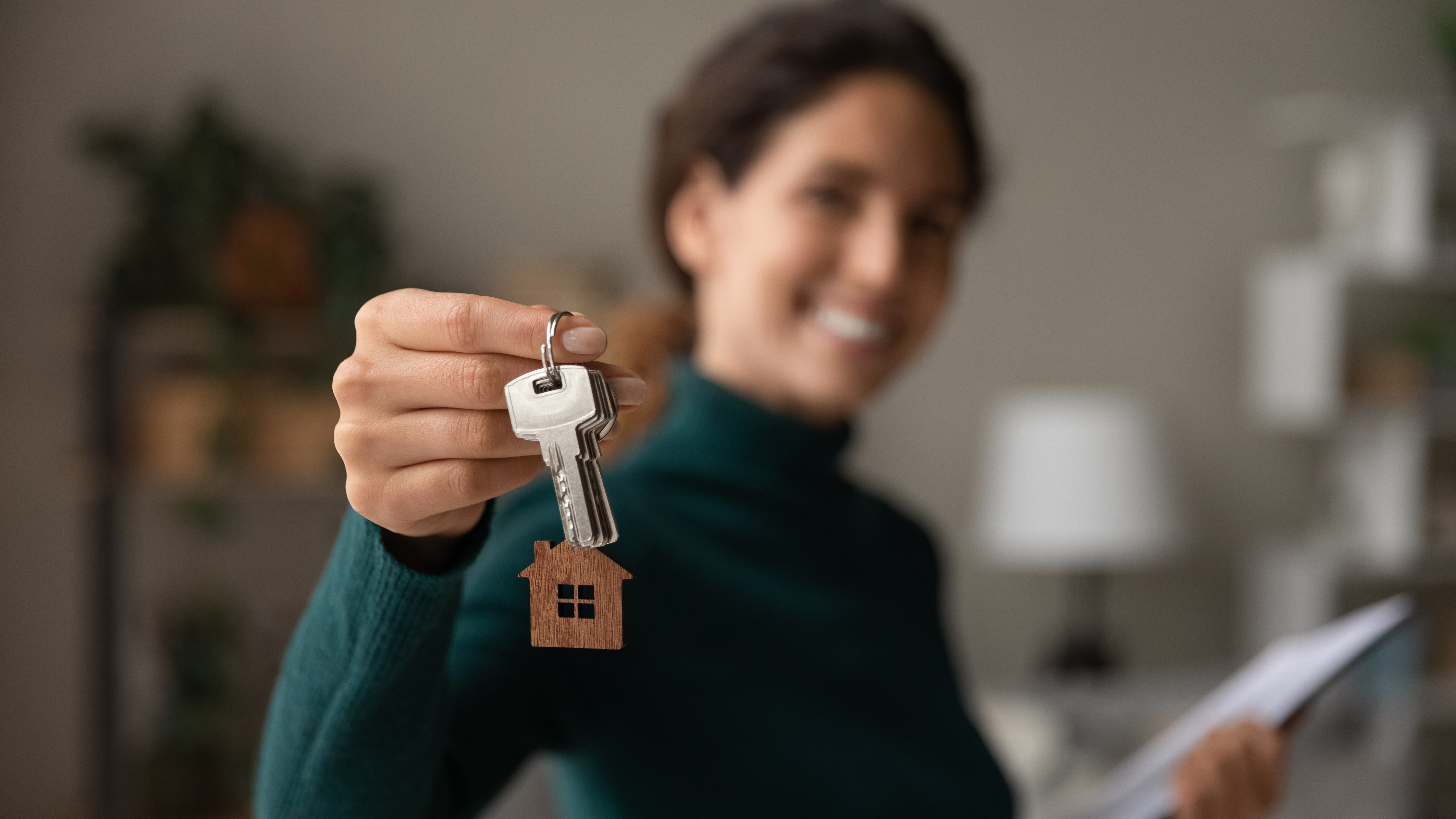 person-holding-house-keys-with-small-home-keychain