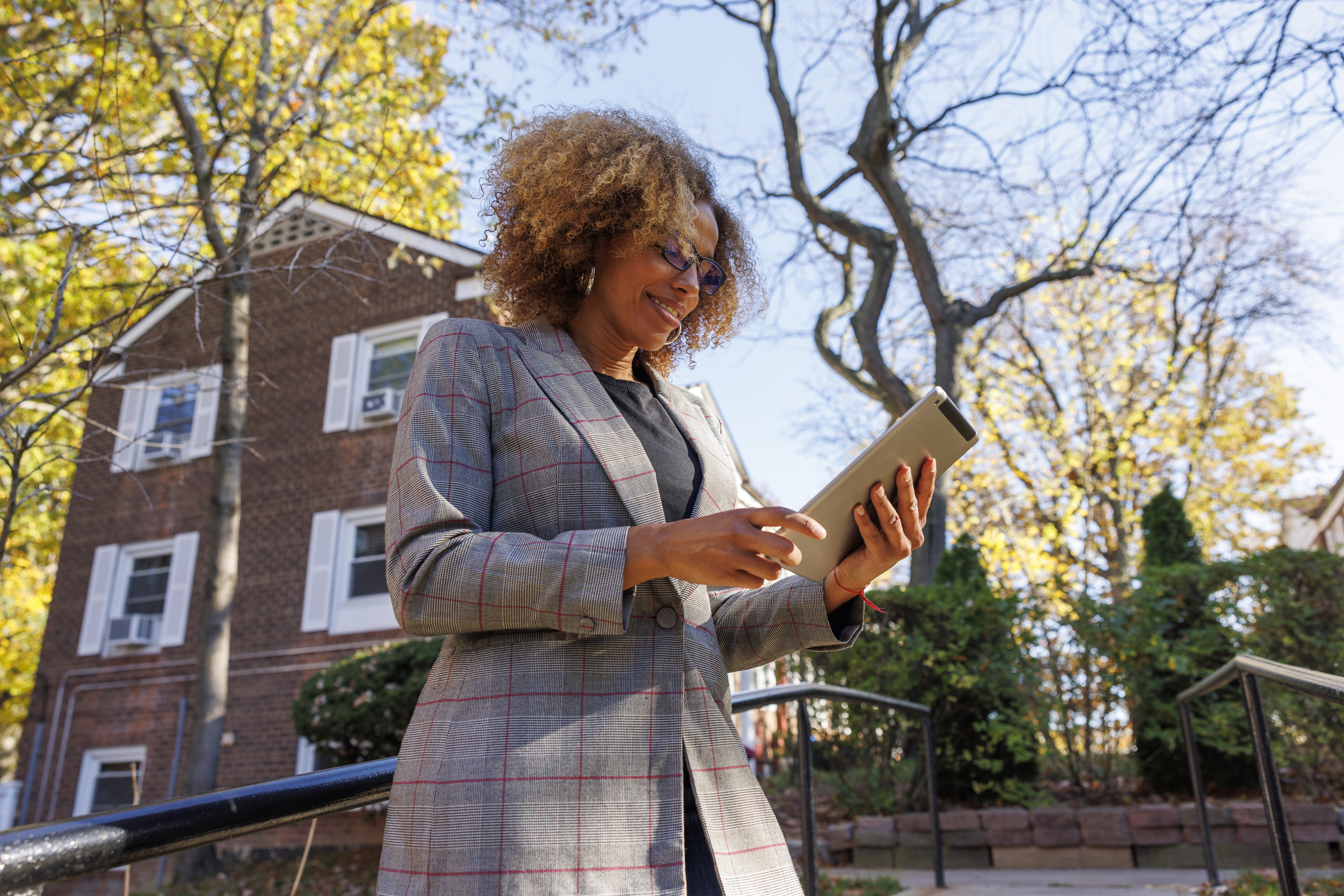 person-standing-outdoors-using-tablet-near-brick-building