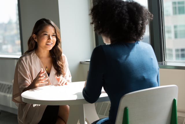 Two people sitting across from each other at a table